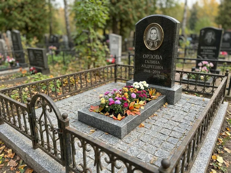 Благоустроенное захоронение с гранитной плиткой, оградой и цветником в Южно-Сахалинске