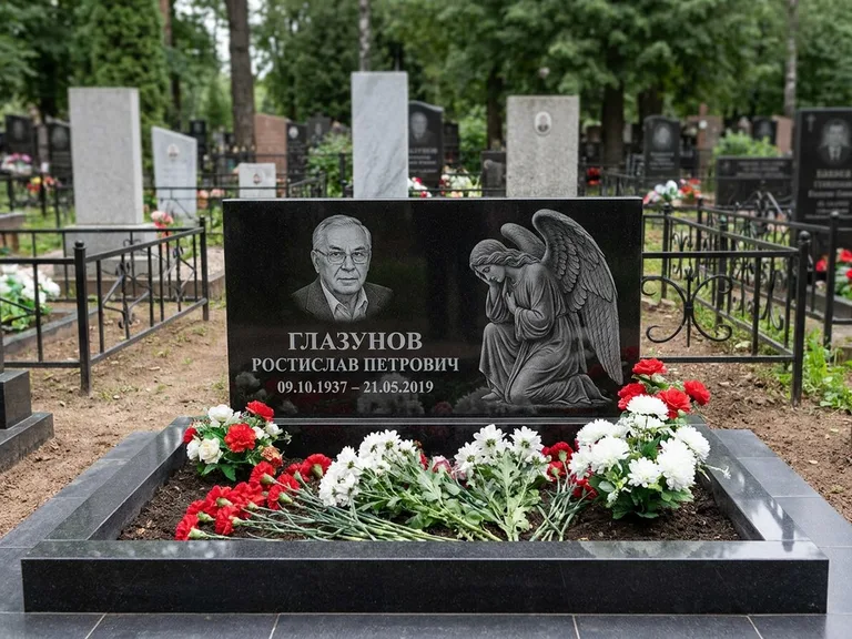 Памятник с гравировкой ангела — гравировка молящегося ангела в верхней части стелы, работа «Доронин» в Южно-Сахалинске