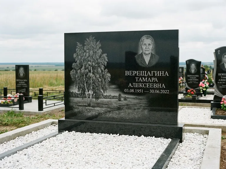 Памятник с гравировкой берёзы: широкая горизонтальная стела — берёза у поля, простор до горизонта, белая мраморная крошка с бордюром, работа «Верещагина» в Южно-Сахалинске