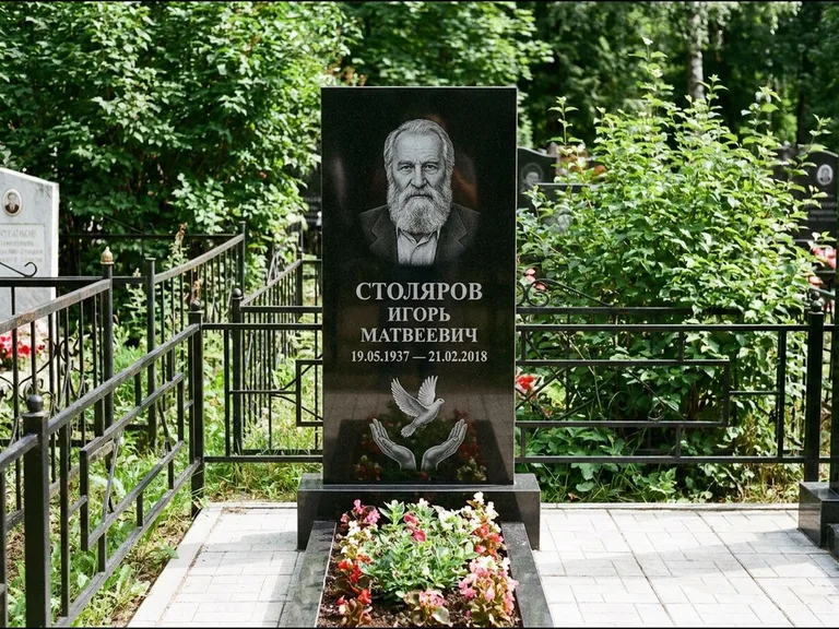 Памятник с гравировкой голубей — гравировка голубя над раскрытыми ладонями внизу стелы, работа «Столяров» в Южно-Сахалинске