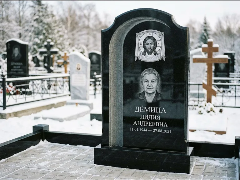Памятник с гравировкой иконы: гранёный восьмиугольный обелиск с крестом — гравировка Николая Чудотворца, семейный участок с гранитной скамьёй, работа «Зотов» в Южно-Сахалинске