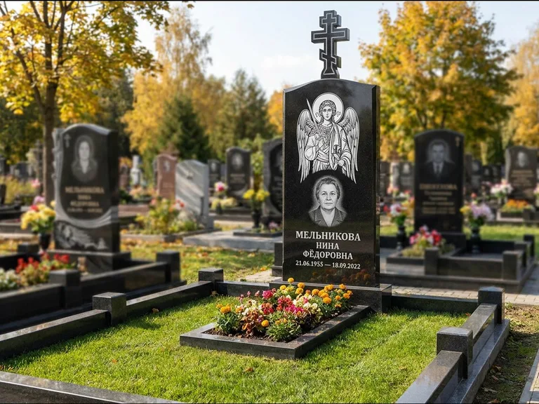 Памятник с гравировкой иконы: округлая стела-медальон с ликом — гравировка Богородицы «Семистрельная», луговые травы и полевые цветы за участком, работа «Гущин» в Южно-Сахалинске