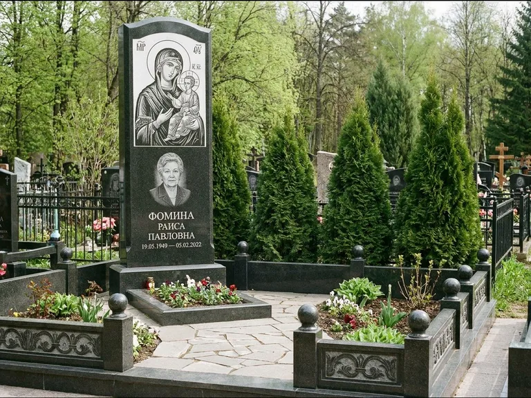 Памятник с гравировкой иконы: высокий гранёный обелиск с крестом-навершием — гравировка образа Матроны Московской, открытый участок без ограды, работа «Третьяков» в Южно-Сахалинске