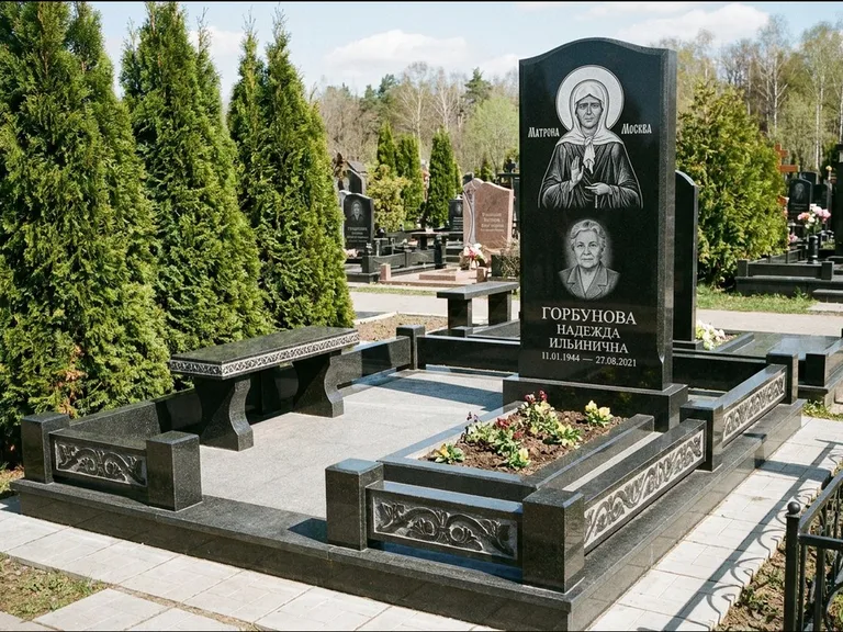 Памятник с гравировкой иконы: стела в форме раскрытой книги с образом — гравировка образа Спасителя, цоколь тёмной плиткой, работа «Зотов» в Южно-Сахалинске