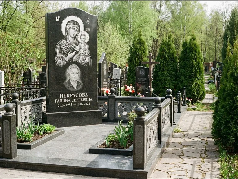 Памятник с гравировкой иконы: полукруглая стела с купольным навершием — Архангел Михаил на стеле, заснеженный зимний участок, работа «Гущин» в Южно-Сахалинске