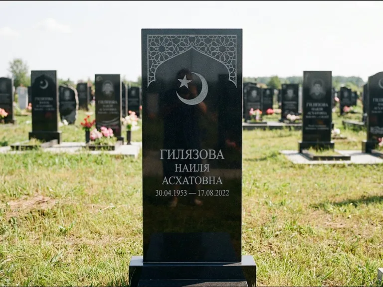 Мусульманский памятник: узкая вертикальная стела-пилон с полумесяцем — гравировка мечети в михраб-арке с орнаментом, открытая лужайка без ограды, работа «Ибрагимова» в Южно-Сахалинске