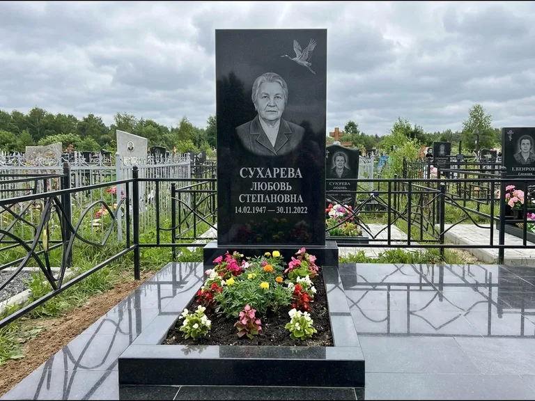 Памятник с гравировкой журавлей — гравировка одиночного летящего журавля над портретом, работа «Сухарева» в Южно-Сахалинске