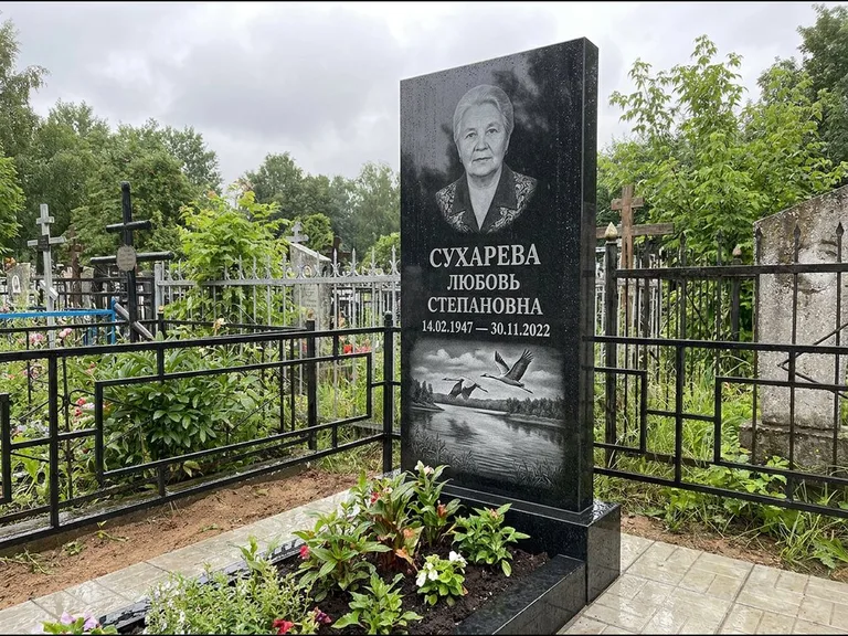 Памятник с гравировкой журавлей — гравировка пары журавлей над гладью озера в нижней части, работа «Сухарева» в Южно-Сахалинске