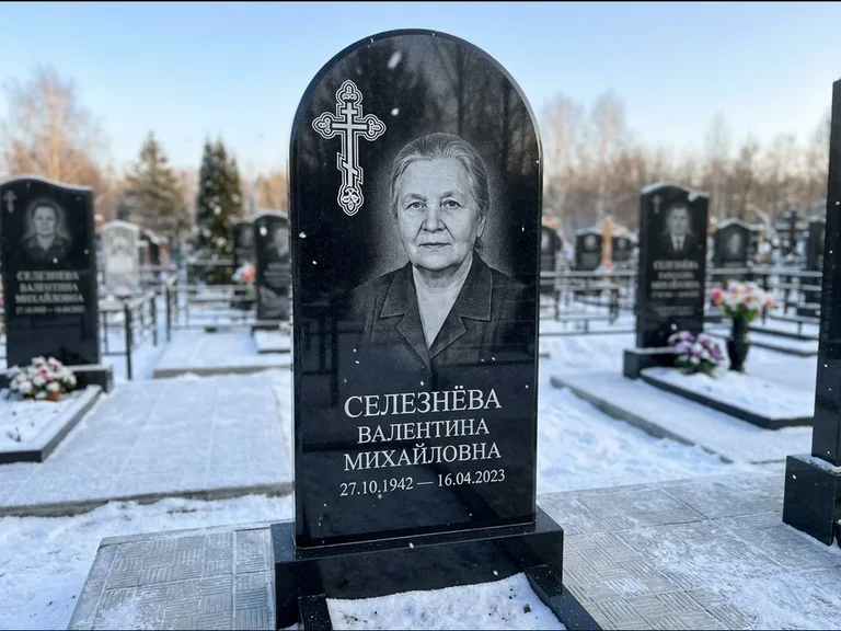 Памятник из чёрного гранита — массивная стела с крестом в лучах с крестом в лучах, работа «Одинцова» в Южно-Сахалинске