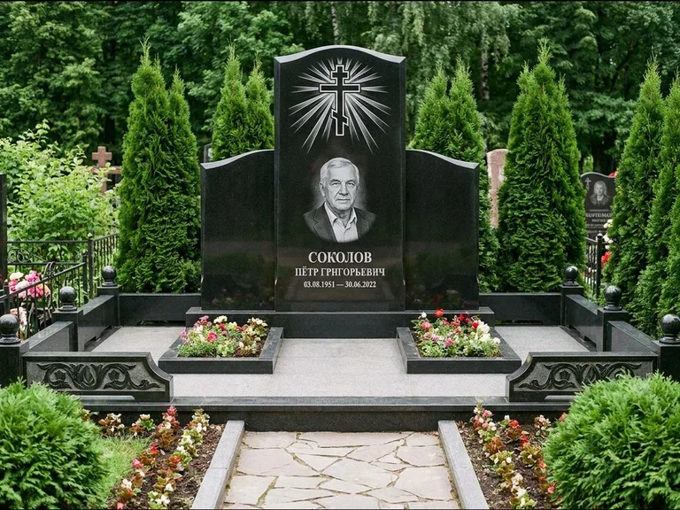 Памятник из чёрного гранита — низкая стела с крестом сбоку с золочёным крестом, работа «Верещагин» в Южно-Сахалинске