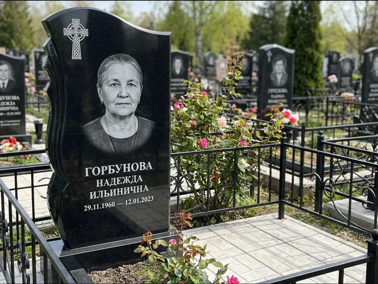 Памятник из чёрного гранита — высокий обелиск с кельтским крестом, работа «Одинцова» в Южно-Сахалинске